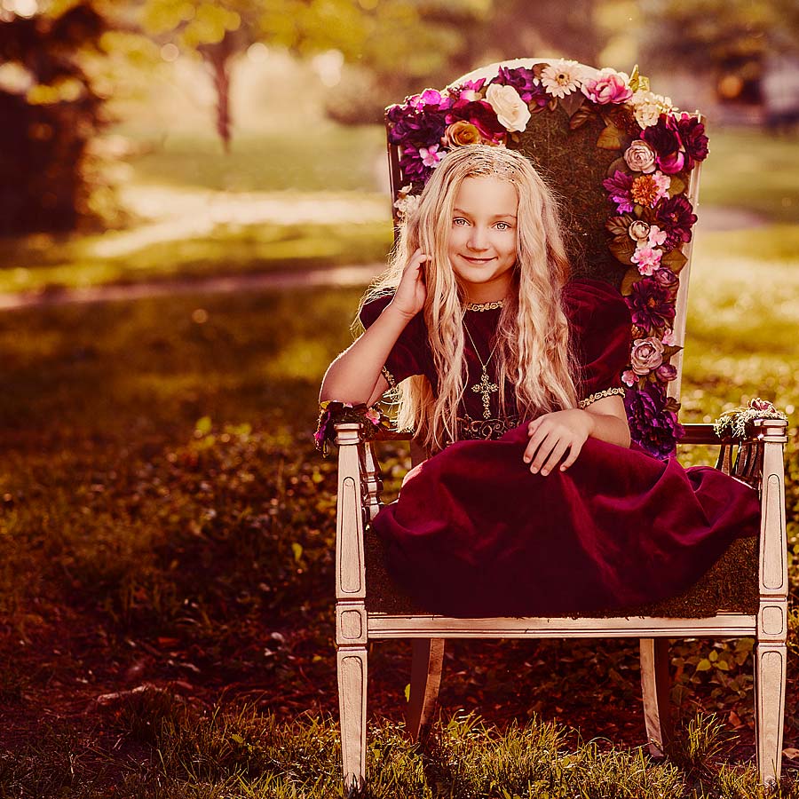 Girl dressed as Princess sitting in a Moss and flower covered throne taken by Louisbille Child Photographer for Princess Mini Sessions