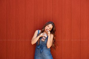 Woman enjoying frappe from Coffee Zone in Westport Village while wearing jumpsuit from Apricot Lane