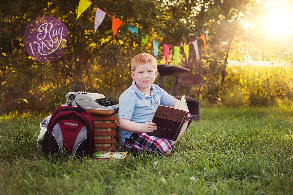 Boy holding science textbook during Back to School Minisessions with Louisville Child Photographer