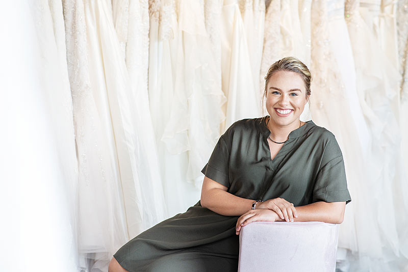 Store Owner of Fabulous Frocks in Front of Wedding Dresses by Louisville Branding Photographer