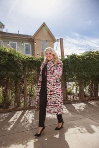 Woman walking in Westport Village wearing long colorful coat from collections Boutique by Louisville Photographer