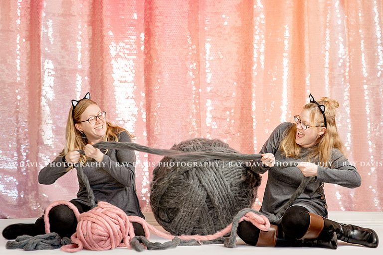 Twins playing tug of war with yarn ball for cat themed 30th Bday session