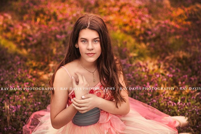 teen ballerina sitting in clover field taken by Ray Davis Photography